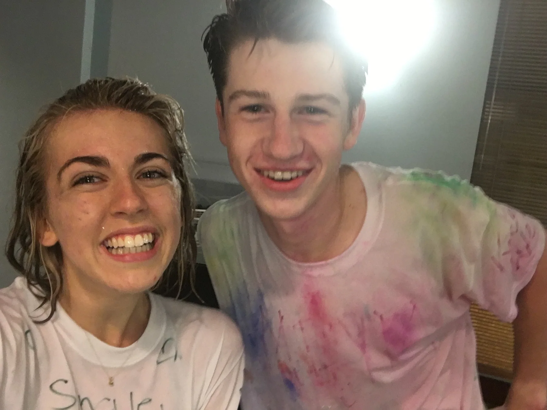Anna Margaret and Hugh smiling together after getting covered in bright colors