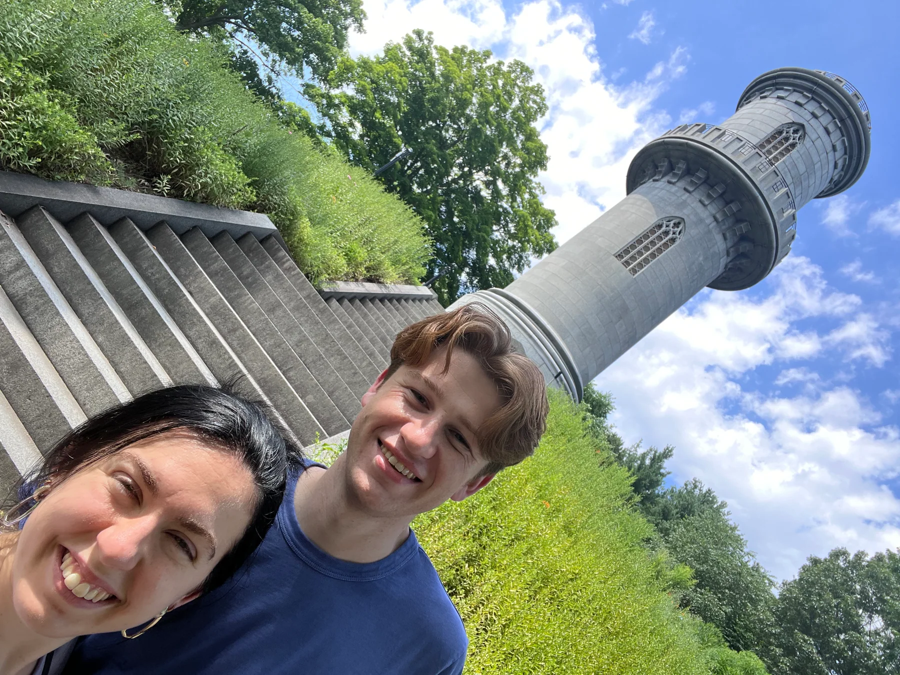 Anna Margaret and Hugh beside a stone tower in a park